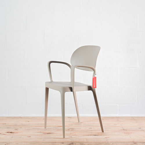 Side view of Alma Amy stacking chair with armrests in Sand